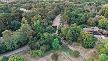 Yazın günbatımında ağaçların ve doğanın içinden geçen yollar ve arabalarla Victoria şehir parkının sol alt köşesini hızla tarıyor.