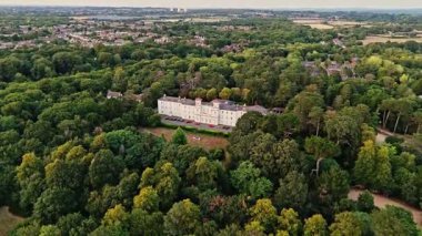 Hava aracı, yazın günbatımında doğa ve ağaçlarla çevrili İngiliz beyaz malikanesinin uzak köşkünden uçuşa geçti.