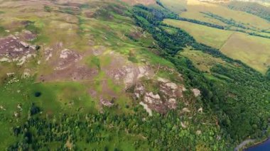 İngiltere Gölü Tepesi 'nin üzerini çevreleyen çim ve ağaçlarla kaplı ve göl suyuyla kaplayan insansız hava aracı çekim yaptı.