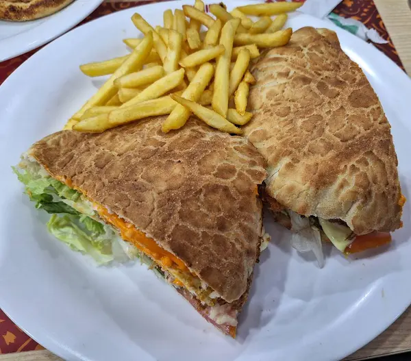 Taze marulla doldurulmuş lezzetli dev bir sandviç, erimiş peynir dilimleri, ve diğer lezzetli malzemeler, çıtır altın kızartmalarla servis ediliyor. Sıradan bir restoranda leziz bir yemek için mükemmel..