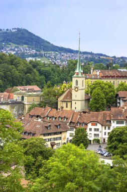 30 Mayıs 2023, Bern, İsviçre. Aare Nehri üzerindeki taş köprü ve Nydeggkirche çan kulesi. Yüksek kalite fotoğraf