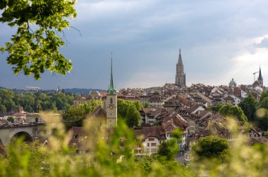 30 Mayıs 2023, Bern, İsviçre. Aare Nehri üzerindeki taş köprü ve Nydeggkirche çan kulesi. Yüksek kalite fotoğraf