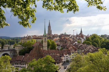 30 Mayıs 2023, Bern, İsviçre. Aare Nehri üzerindeki taş köprü ve Nydeggkirche çan kulesi. Yüksek kalite fotoğraf