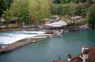 Aare Nehri kıyısındaki Riverside Cafe, Bern. İsviçre 'nin Bern kentinde Aare Nehri' nin kıyısına inşa edilmiş samimi bir nehir kenarı kafe. Ağaçların arasına kurulmuş ve küçük bir bataklığa bakan bu eşsiz konum,