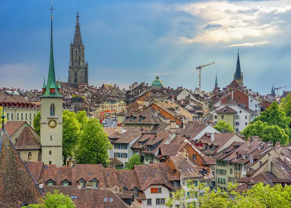 Bern, İsviçre, 30 Mayıs 2024. Bu görüntü, tarihi Nydeggkirche ve Bern Minster 'ın yer aldığı Bern, İsviçre' nin çarpıcı siluetini yakalar. Sahne ortaçağ cazibesini vurguluyor.