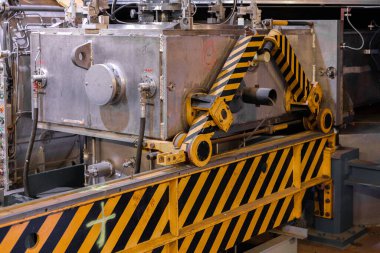 Parçacık hızlandırıcı altyapısında kullanılan siyah ve sarı çizgili metalik ekipmanları gösteren CERN içindeki bir teknik cihazın yakın çekimi. 20 Haziran 2023. Yüksek kalite fotoğraf