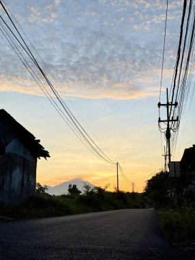 Dağ ve elektrik direkleriyle köy yolu.