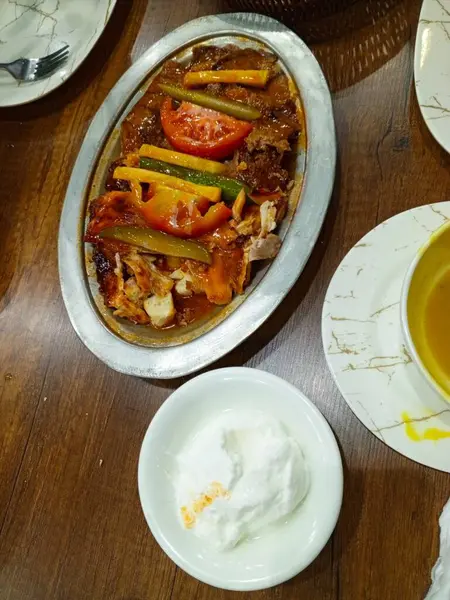 Izgara et, domates sosu, taze sebze ve yanında kremalı yoğurt ile servis edilen Türk İskender kebabı otantik bir Orta Doğu yemeği yakaladı.,