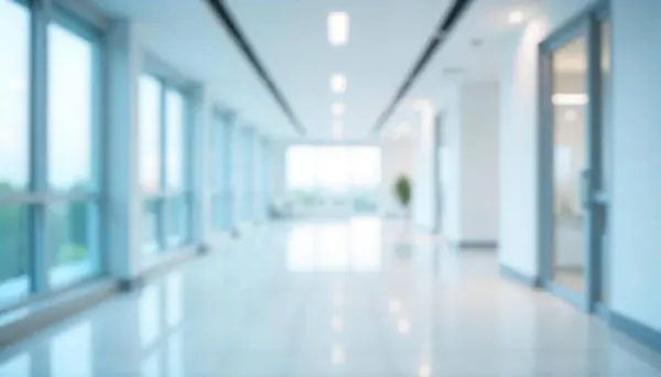 Modern bulanık ofis koridoru parlak doğal ışık, cam kapılar ve pencerelerle. Ticari, kurumsal veya soyut arkaplan amaçları için kullanılan minimalist iç mekan.