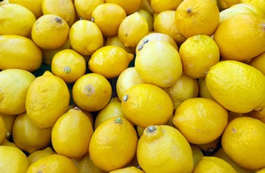Taze sarı limonlar canlı ve yakın çekim bir arada. Tazelik, turunçgiller, sağlıklı yiyecekler ve doğal malzemeler için mükemmel bir tema..