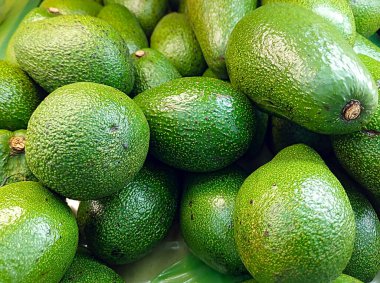 Markette canlı bir yeşil avokado gösterisi, sağlık, beslenme, vegan yaşam tarzı ve temiz yemek görselleri için ideal..
