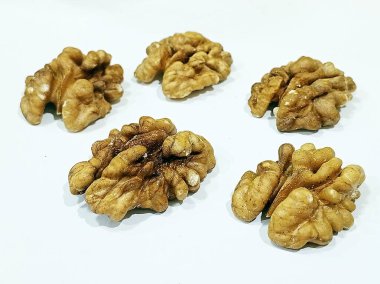 Beyaz arka planda çiğ ceviz yarımları, sağlıklı organik fındıklar, omega-3 yağ asitleri, doğal beyin gıdaları, aperatifler, pişirme ve kalp sağlığı için mükemmel..