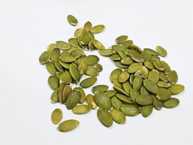 Beyaz zemin üzerinde çiğ balkabağı tohumları, magnezyum, lif, bitki proteini, keto-dostu, salata, fırın ve besleyici beslenme için mükemmel sağlıklı organik atıştırmalıklar..