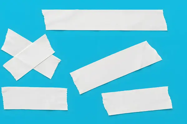 Canlı mavi arkaplanda izole edilmiş yırtık beyaz maskeleme bantları koleksiyonu, tasarım kullanımı için mükemmel