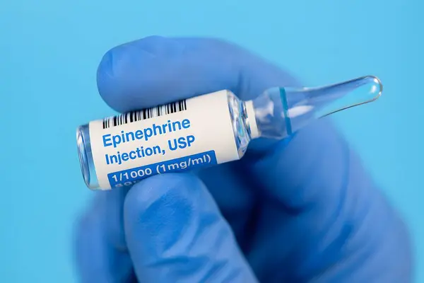 Epinefrin enjeksiyonu, eldivenli ellerle tutulan usp ampulü, acil tıp için mükemmel, yoğun bakım, ilaç reklamları ve sağlık hizmetleri içeriği.