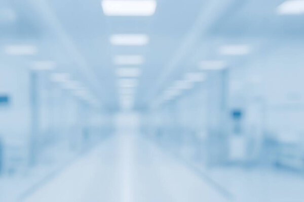 Размытый коридор в стерильном медицинском или лабораторном учреждении с ярким освещением и стеклянными панелями, символизирующий клиническую точность и современный дизайн здравоохранения.