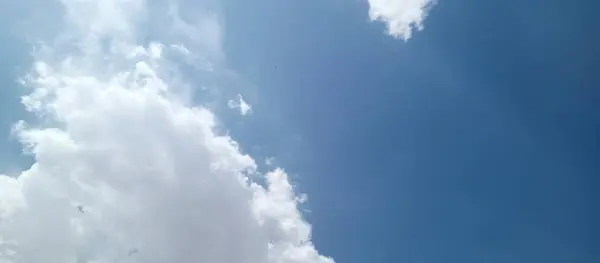 Dağınık bulutlu parlak mavi gökyüzü, temiz havayı, çevresel farkındalığı ve kirliliği azaltma ve kamu sağlığını koruma amaçlı küresel çabaları sembolize ediyor