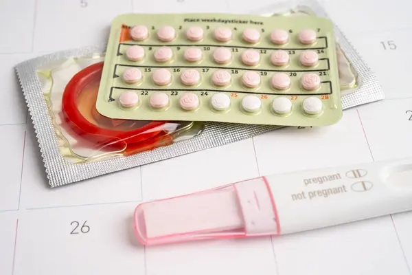 Gebelik testi ve takvimde kadınlar için prezervatif, yumurtlama günü.