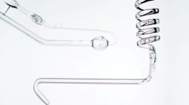 Beyaz zemin üzerinde sıvı bulunan cam test tüpleri.