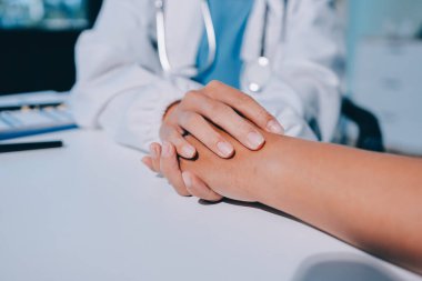 Yakın plan, doktor yaşlı bir kadınla el ele tutuşuyor ve kanser bakımı ya da destek. Sağlık hizmetleri veya güven, empati veya şefkat ve kadın bakıcı veya hemşire umut ve şefkat için yaşlı kişinin elini tutuyor.