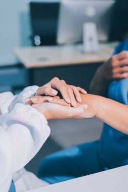 Yakın plan, doktor yaşlı bir kadınla el ele tutuşuyor ve kanser bakımı ya da destek. Sağlık hizmetleri veya güven, empati veya şefkat ve kadın bakıcı veya hemşire umut ve şefkat için yaşlı kişinin elini tutuyor.