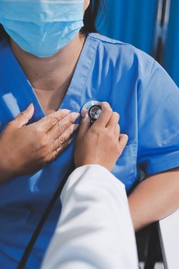 Ev bakımı hemşiresi ve yaşlılar kardiyoloji sağlık hizmetleri. Genç İspanyol kadın doktor hemşirenin yakın çekimleri sırasında steteskop kullanarak olgun beyaz hasta kalp atışlarını kontrol et.