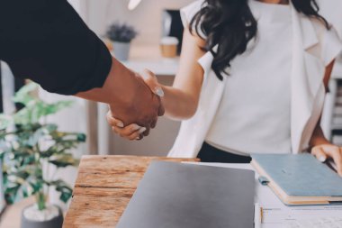 Başarılı Asyalı genç adam, erkek ortaklığı, takım çalışması tokalaşması ya da proje tamamlandıktan sonra ofiste birlikte selamlaşma, iyi anlaşma. Mutlu iş adamları, işçi ya da grup toplantısı, el sıkışma konsepti.