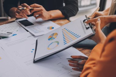 Bilgisayarda dijital tablet ve analitik fiyat grafikleriyle çalışan Asyalı işadamı ve kadın ofis masası, iş finans ve muhasebe analitik kavramı.