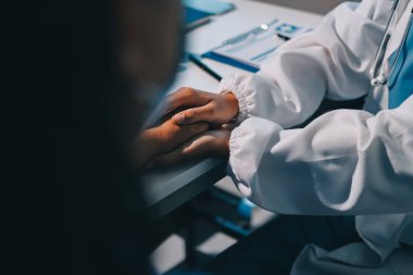 Yakın plan, doktor yaşlı bir kadınla el ele tutuşuyor ve kanser bakımı ya da destek. Sağlık hizmetleri veya güven, empati veya şefkat ve kadın bakıcı veya hemşire umut ve şefkat için yaşlı kişinin elini tutuyor.