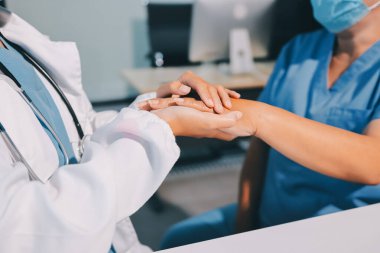 Yakın plan, doktor yaşlı bir kadınla el ele tutuşuyor ve kanser bakımı ya da destek. Sağlık hizmetleri veya güven, empati veya şefkat ve kadın bakıcı veya hemşire umut ve şefkat için yaşlı kişinin elini tutuyor.