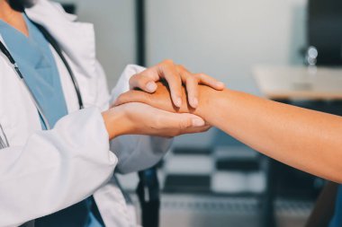 Yakın plan, doktor yaşlı bir kadınla el ele tutuşuyor ve kanser bakımı ya da destek. Sağlık hizmetleri veya güven, empati veya şefkat ve kadın bakıcı veya hemşire umut ve şefkat için yaşlı kişinin elini tutuyor.