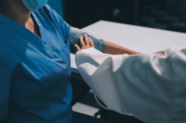 Steteskopla sfenometre kullanan bir doktor hastanede kan basıncını ölçüyor..