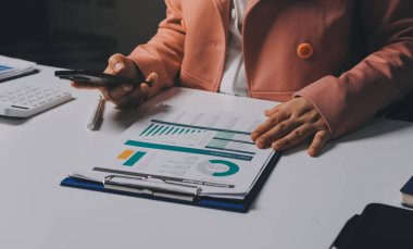 Ofisinde dizüstü bilgisayarla çalışan profesyonel bir iş kadınının görüntüsü. Genç bayan yönetici, modern çatı katında otururken taşınabilir bilgisayar kullanıyor. İşaret fişeği ışığı, iş süreci kavramı.