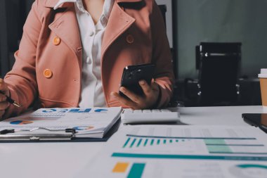 Ofisinde dizüstü bilgisayarla çalışan profesyonel bir iş kadınının görüntüsü. Genç bayan yönetici, modern çatı katında otururken taşınabilir bilgisayar kullanıyor. İşaret fişeği ışığı, iş süreci kavramı.