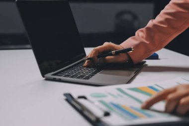 Ofisinde dizüstü bilgisayarla çalışan profesyonel bir iş kadınının görüntüsü. Genç bayan yönetici, modern çatı katında otururken taşınabilir bilgisayar kullanıyor. İşaret fişeği ışığı, iş süreci kavramı.