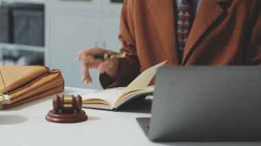 Ofisteki iş yerinde belge ve bilgisayarla çalışan bir avukat. Hukuki danışmanlık, hukuk ve adalet kavramı.