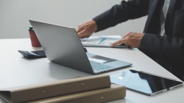 İş adamları büroda dizüstü bilgisayarla çalışıyorlar.