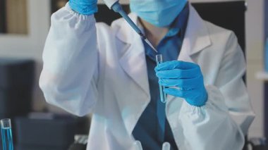 Laboratuvarda çalışan bir bilim adamı. Bilim adamı laboratuvarda çalışıyor. Sıvı içeren bir test tüpü.