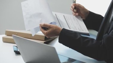 İşadamı ofiste belge ve laptop üzerinde çalışıyor..