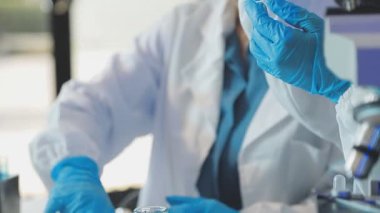 Koruyucu maskeli bilim adamı laboratuarda test tüpleri tutuyor. Coronavirus covid 19.