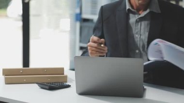 İşadamı ofiste çalışıyor, dizüstü bilgisayar kullanıyor.