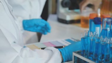 Mikroskop üzerinde çalışan laboratuvar bilim adamı.