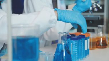 Laboratuvarda deney tüpü tutan bilim adamının yakın çekimi.