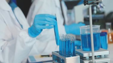 Bilim adamı cam tüpü sıvı halde tutuyor.