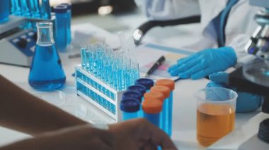 kapalı - mavi eldivenli erkek eller ve sıvı test tüpü