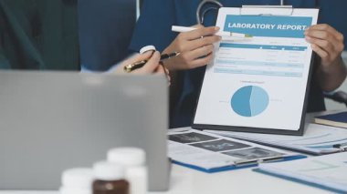 tablet kullanan ve istatistikleri ekranda istatistiklerle analiz eden doktor