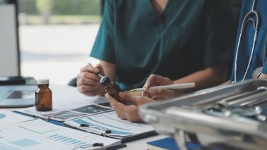 Doktorun elinde pano ve pano, içinde haplar ve hastanedeki hastalarla birlikte.