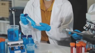 Koruyucu gözlüklü bilim adamı laboratuarda çalışıyor.