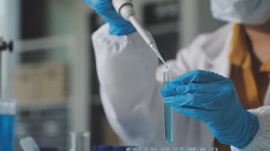 Laboratuarda test tüpleri sıvı ile tutan bilim adamı