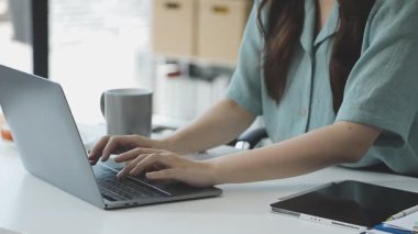 İş kadını ofiste dizüstü bilgisayarla çalışıyor.